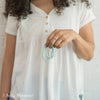 Woman holding two blue companion bracelets