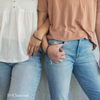 Two women wearing gray companion bracelets