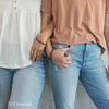 Two women wearing gray companion bracelets