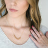 Woman wearing Onward necklace brass fishtail chain