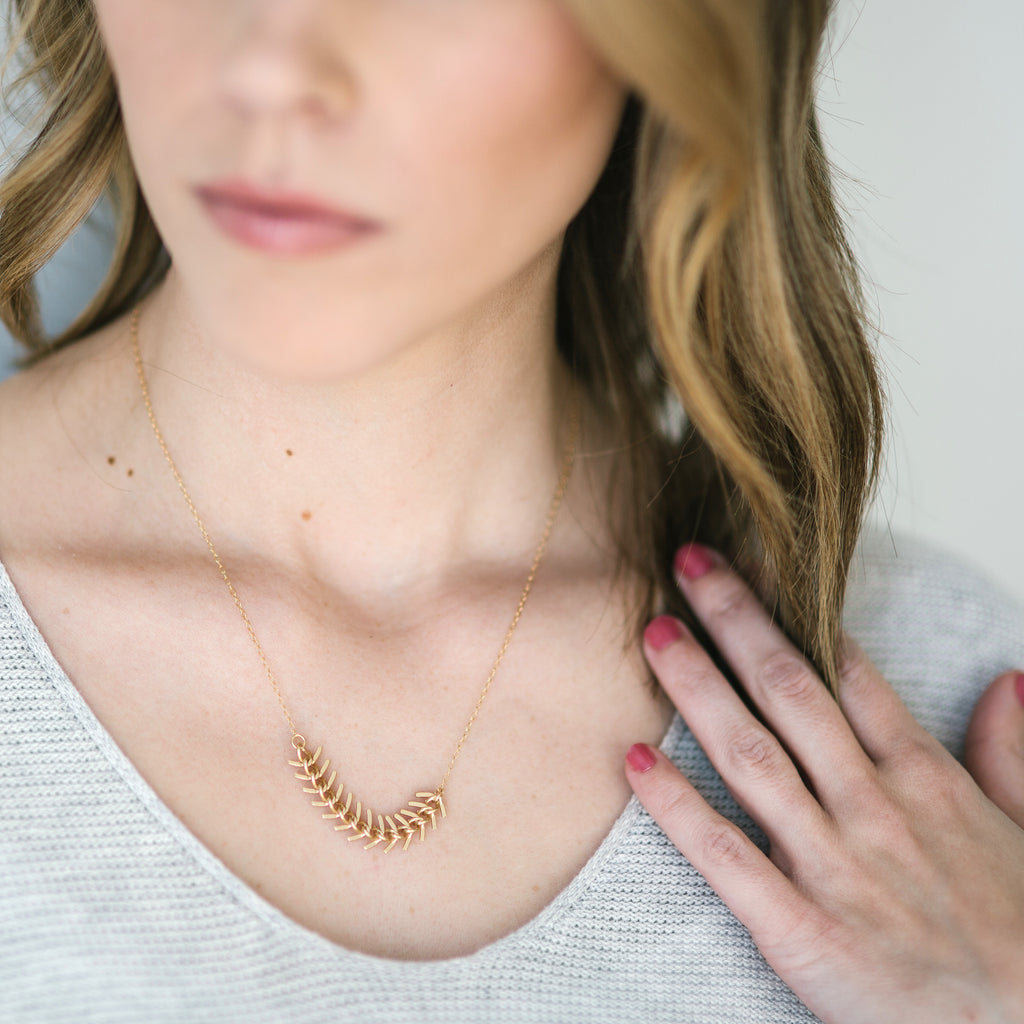 Woman wearing Onward necklace brass fishtail chain