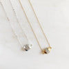 Resolved gold and silver dipped moonstone necklaces on plate