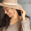 Woman wearing hat and grey tassel earrings