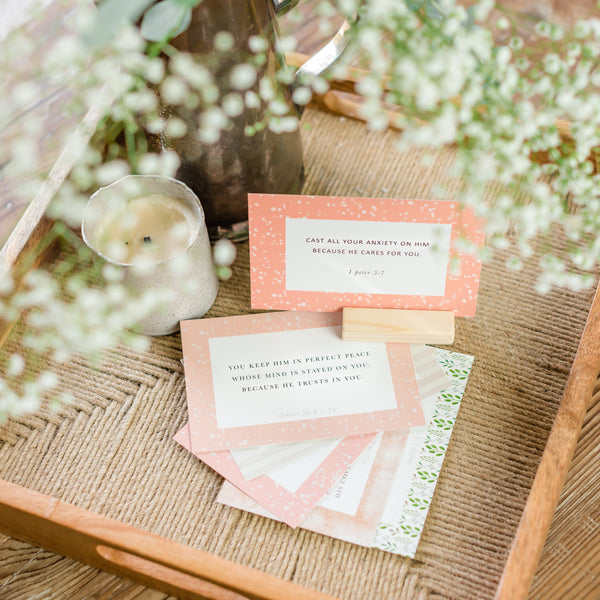 Verse card in wooden stand on tray next to vase and flowers