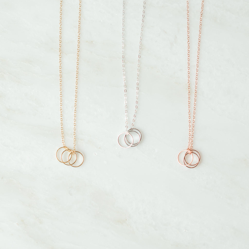 Trio ring necklace in gold, silver, and rose gold