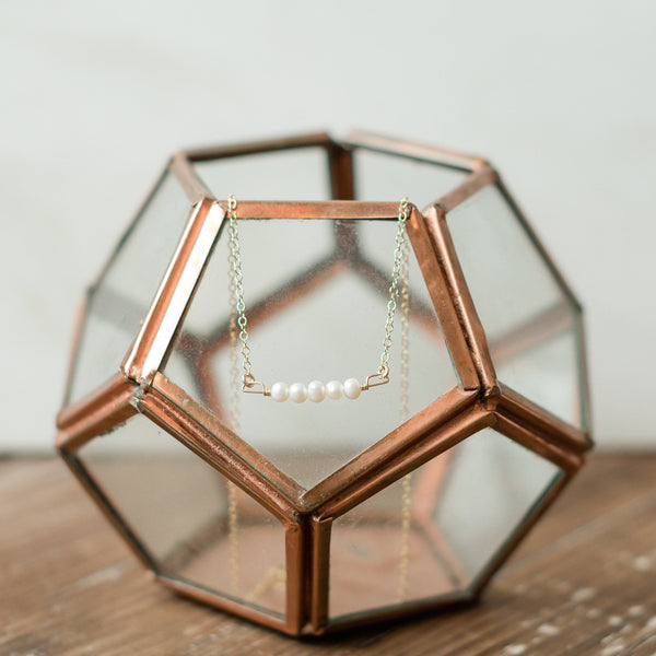 Genuine pearl necklace hanging on glass ball