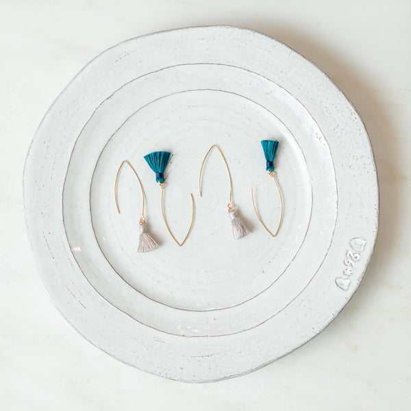 Grey and teal tassel earrings on plate